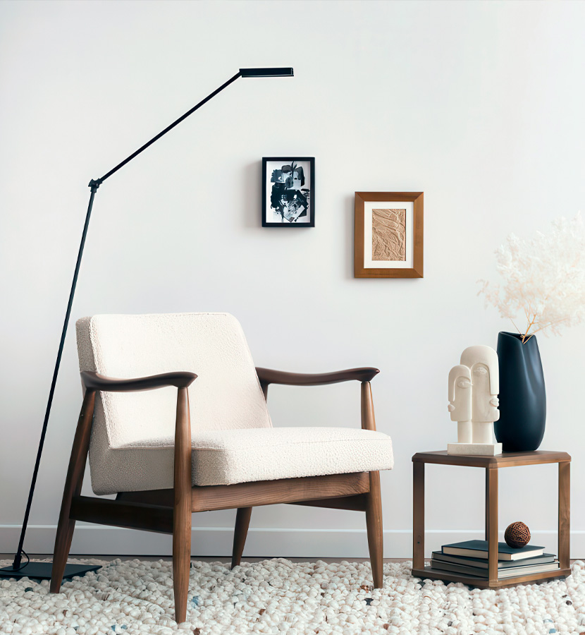 Stilren läslampa bredvid en klassisk fåtölj med träram.