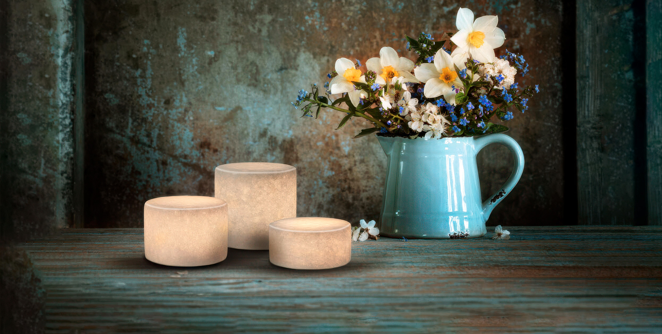 Marmorliknande dekorationslampor bredvid en vas med vackra blommor.